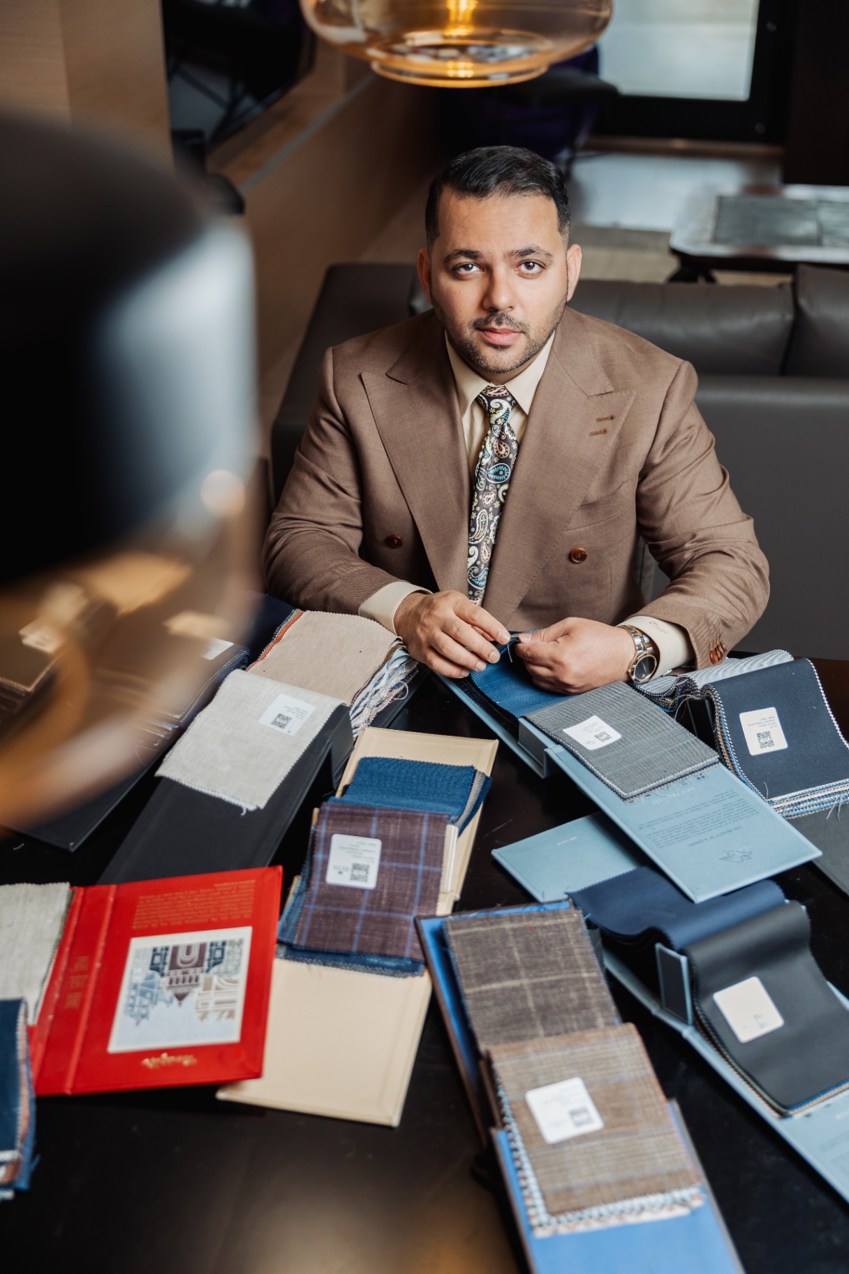 Rajat Nagpal reviewing bespoke fabric swatches at the consultation table