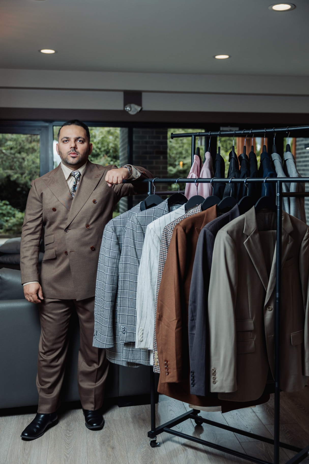 Rajat Nagpal beside a curated rack of bespoke suits at Suited Booted & Co.